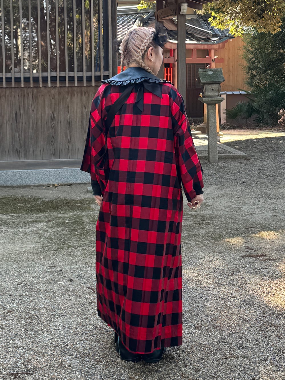 レッド系のスカート、ブラック系のシューズ、ブラック系のファッション雑貨を着用したレディースの冬コーディネートの5枚目の写真