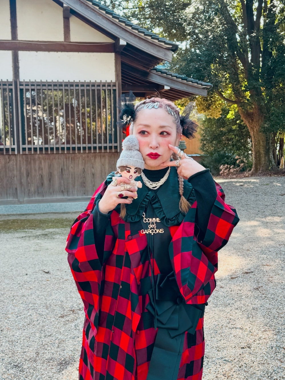 レッド系のスカート、ブラック系のシューズ、ブラック系のファッション雑貨を着用したレディースの冬コーディネートの2枚目の写真