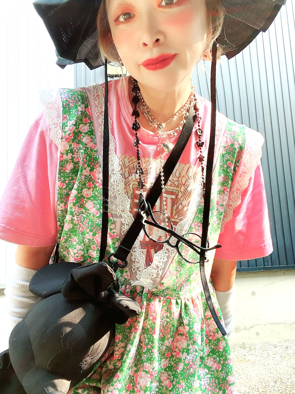 グリーン系のワンピース、ピンク系のTシャツ/カットソー、ブラック系のショルダーバッグを着用したレディースの夏コーディネートの3枚目の写真