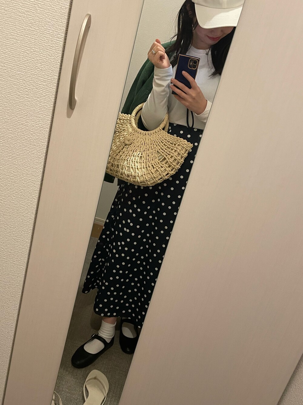 グリーン系のカーディガン/ボレロ、ホワイト系のかごバッグ、ホワイト系のTシャツ/カットソーを着用したレディースの春コーディネートの2枚目の写真