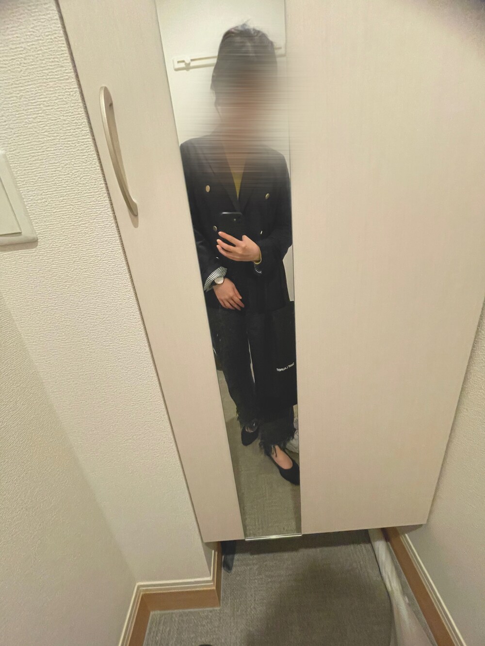 グリーン系のニット/セーター、ブラック系のデニムパンツ、ブラック系のパンプスを着用したレディースの春コーディネートの2枚目の写真