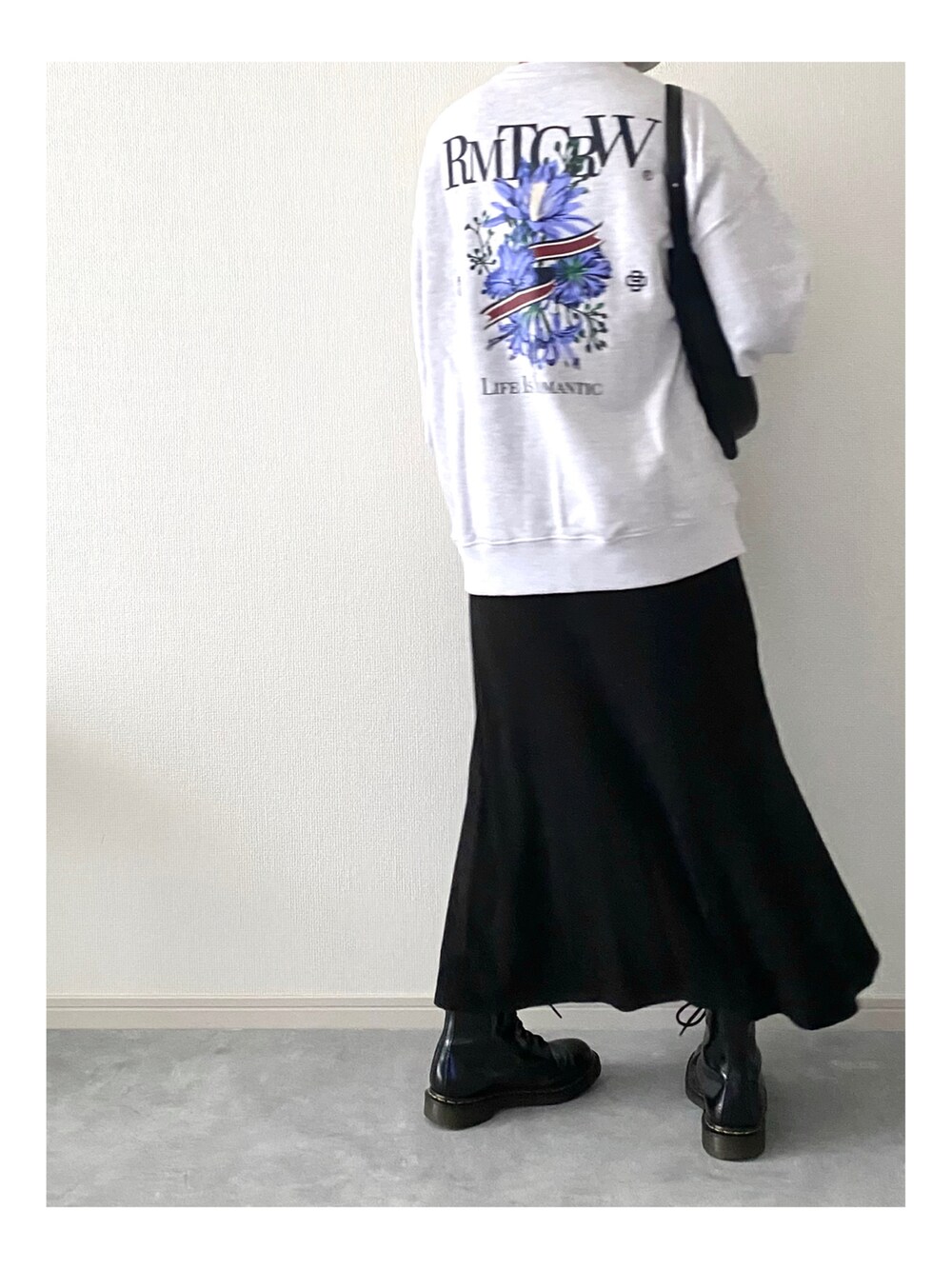 ブラック系のバッグ、オレンジ系のニット/セーター、グレー系のスウェットを着用したレディースの冬コーディネートの2枚目の写真