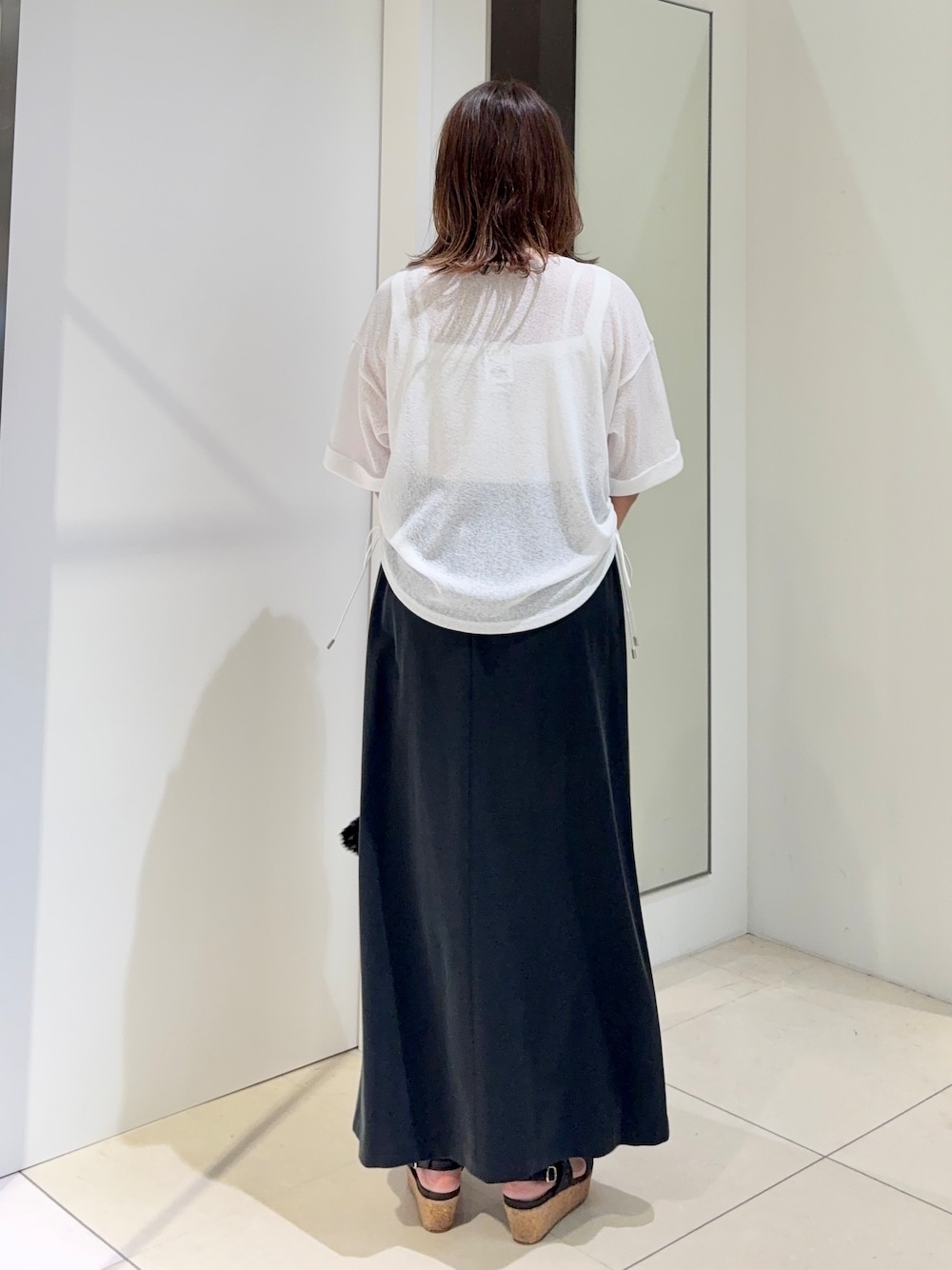 ホワイト系のTシャツ/カットソー、ブラック系のスカートを着用したレディースの夏コーディネートの2枚目の写真