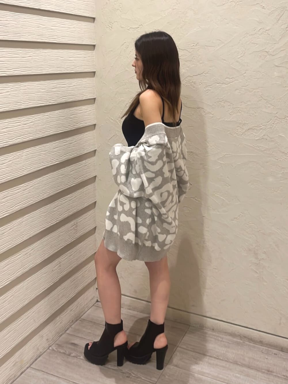 ブラック系のキャミソール、ブルー系のデニムパンツ、ブラック系のブーツを着用したレディースの夏コーディネートの2枚目の写真