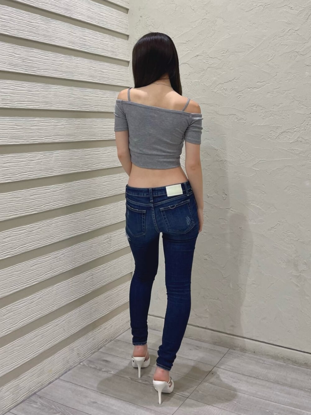 グレー系のTシャツ/カットソー、ブルー系のデニムパンツ、ホワイト系のパンプスを着用したレディースの夏コーディネートの2枚目の写真