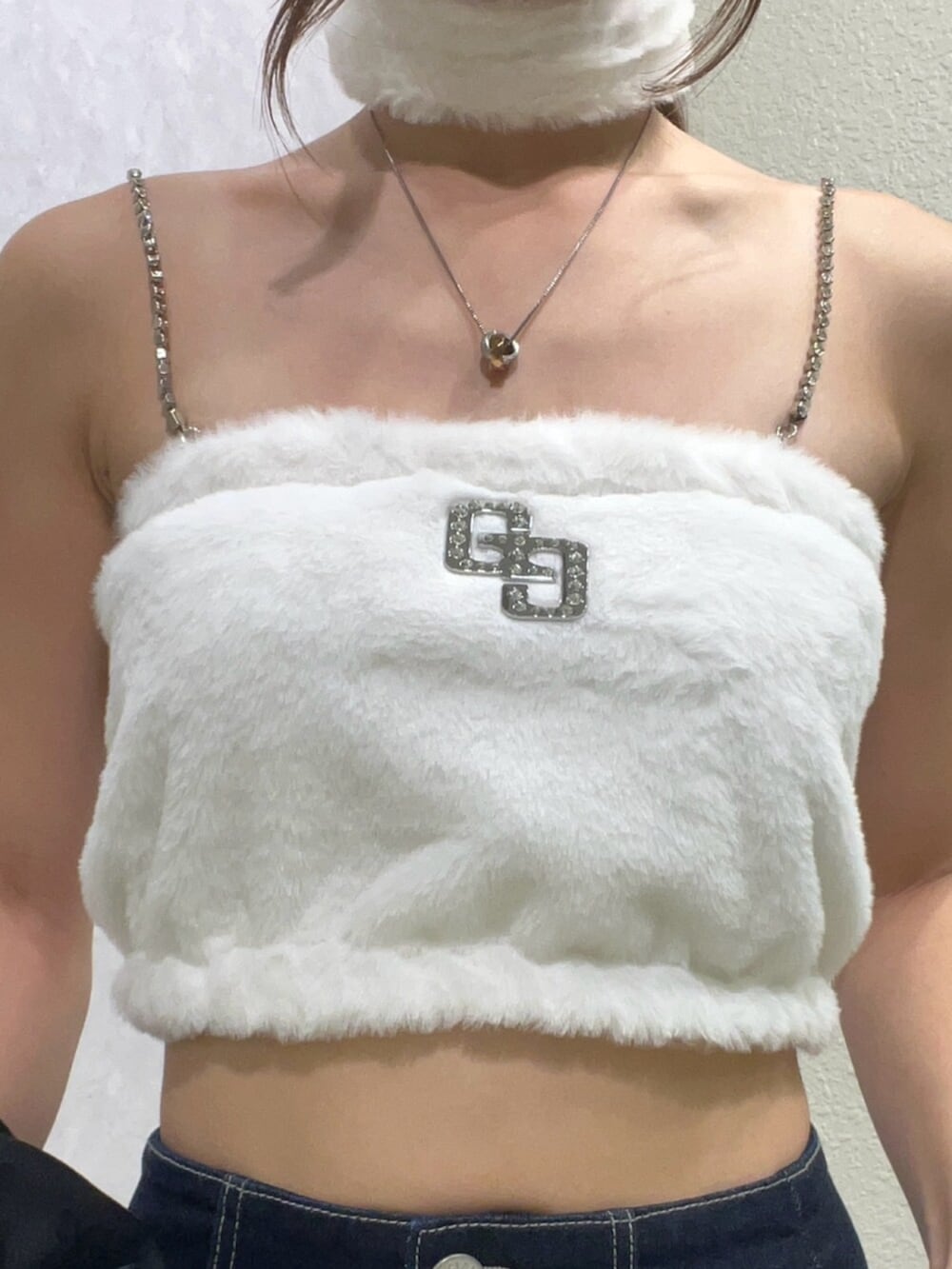 ブラック系のテーラードジャケット、ホワイト系のキャミソール、ブルー系のデニムパンツを着用したレディースの秋コーディネートの5枚目の写真