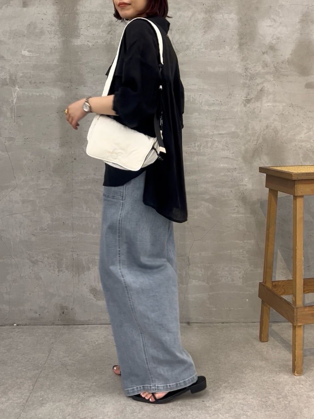 ブルー系のデニムパンツ、ブラック系のシャツ/ブラウス、ブラック系のショルダーバッグを着用したレディースの夏コーディネートの4枚目の写真