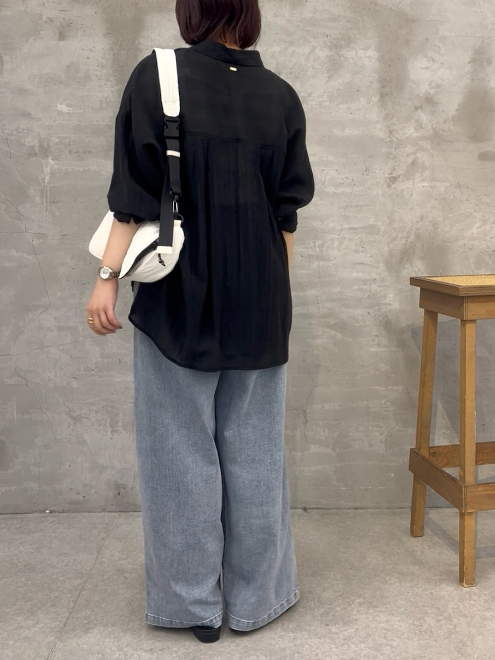 ブルー系のデニムパンツ、ブラック系のシャツ/ブラウス、ブラック系のショルダーバッグを着用したレディースの夏コーディネートの3枚目の写真