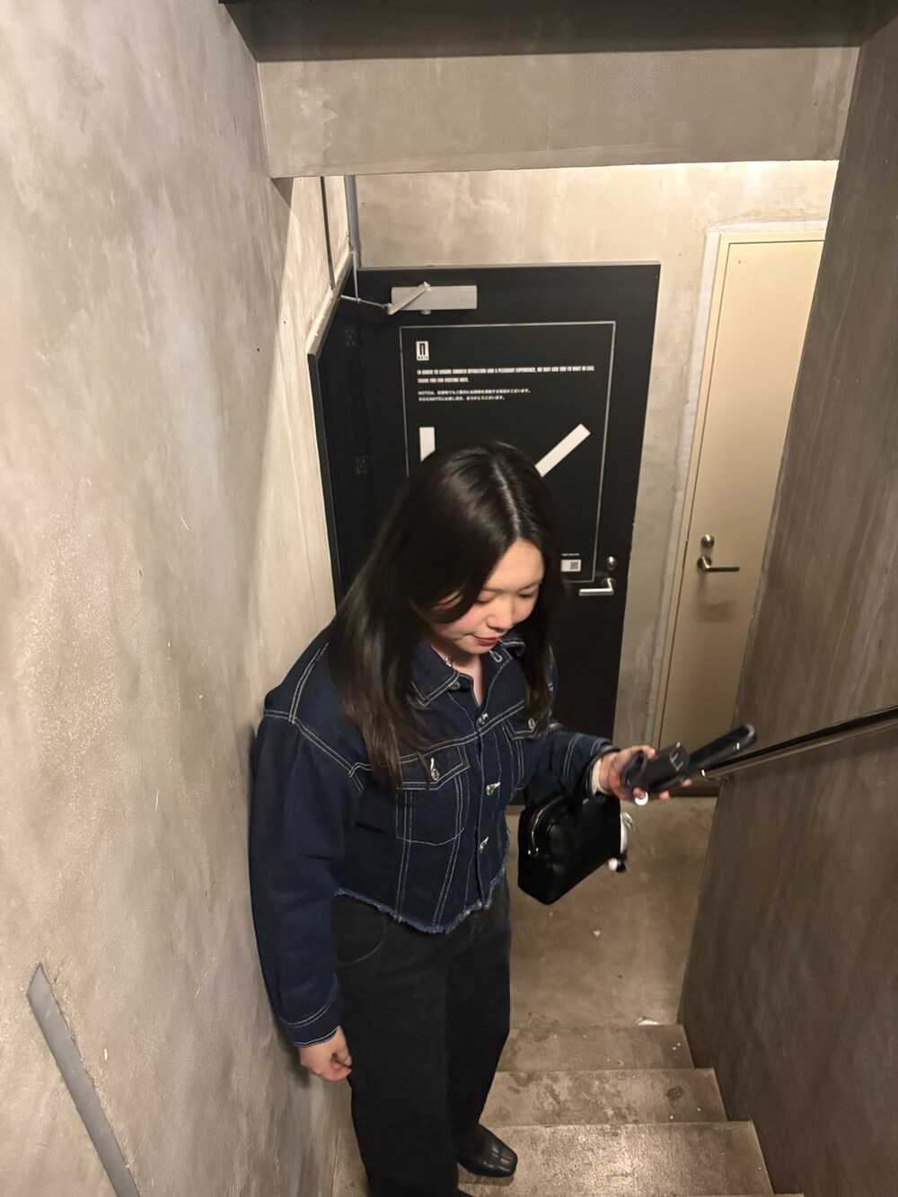 ブラック系のボストンバッグを着用したレディースの秋コーディネートの2枚目の写真