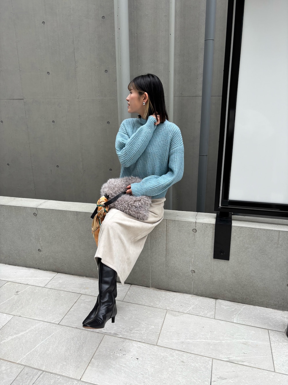 ブルー系のニット/セーター、ベージュ系のスカートを着用したレディースの秋コーディネートの2枚目の写真