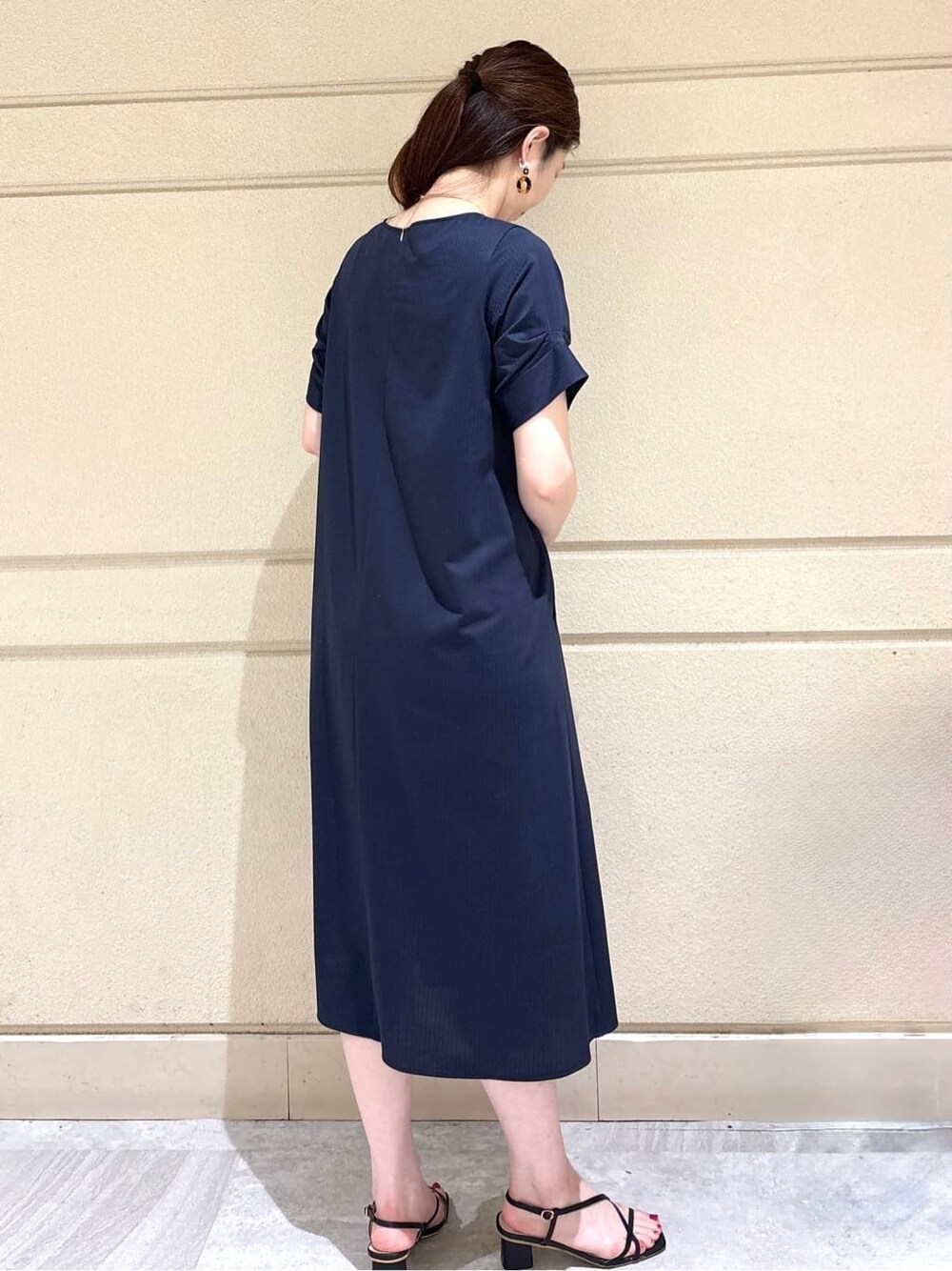 ブルー系のワンピース、グレー系のトートバッグ、シルバー系のネックレスを着用したレディースの夏コーディネートの4枚目の写真
