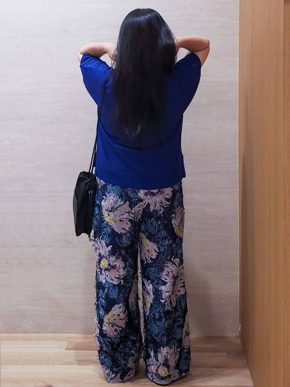 ブルー系のニット/セーター、ブルー系のその他パンツ、ブラック系のショルダーバッグを着用したレディースの夏コーディネートの4枚目の写真