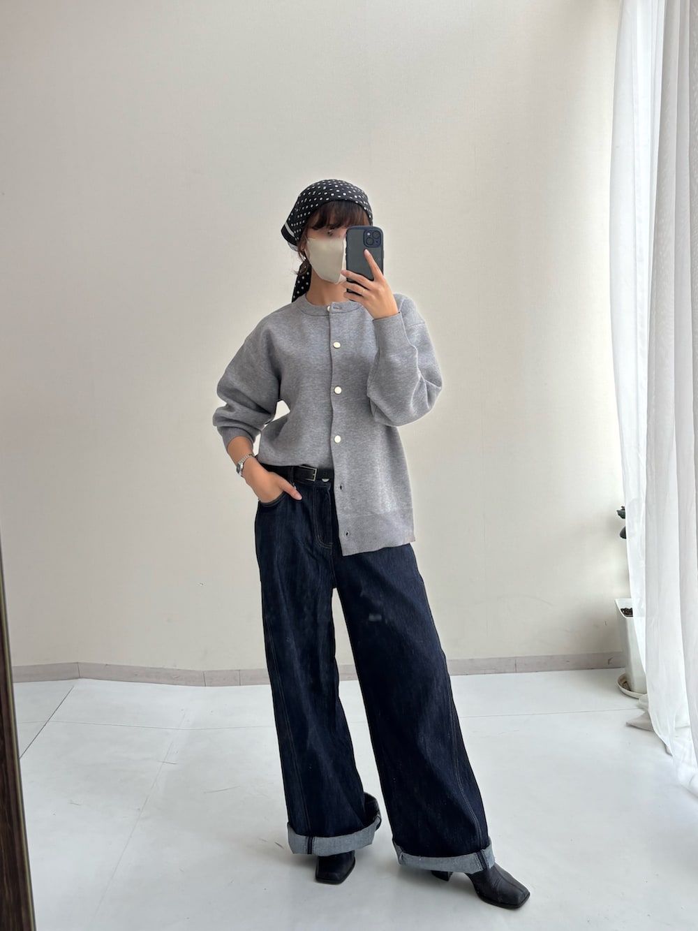 グレー系のカーディガン/ボレロ、ブルー系のデニムパンツ、ブラック系のマフラーを着用したレディースの秋コーディネートの2枚目の写真