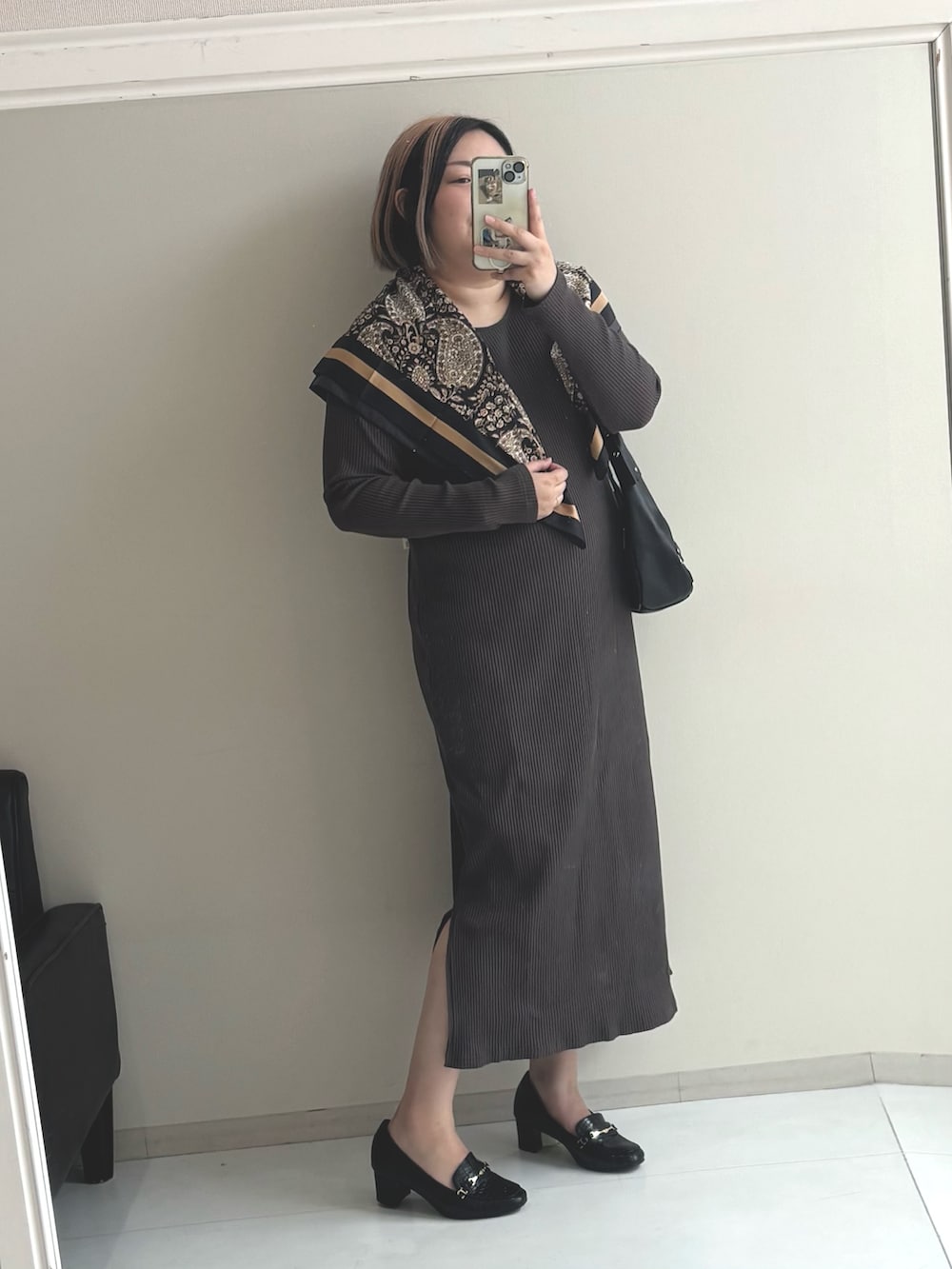 グレー系のワンピース、ブラック系のパンプスを着用したレディースの秋コーディネートの2枚目の写真