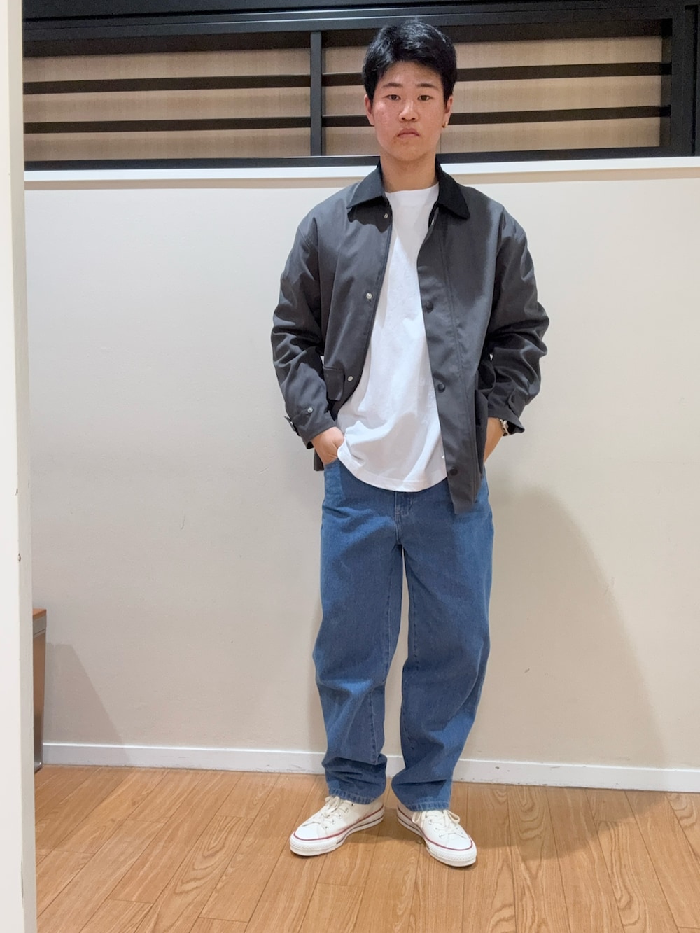 グレー系のその他アウター、ホワイト系のスニーカー、ブルー系のデニムパンツを着用したメンズの春コーディネートの2枚目の写真