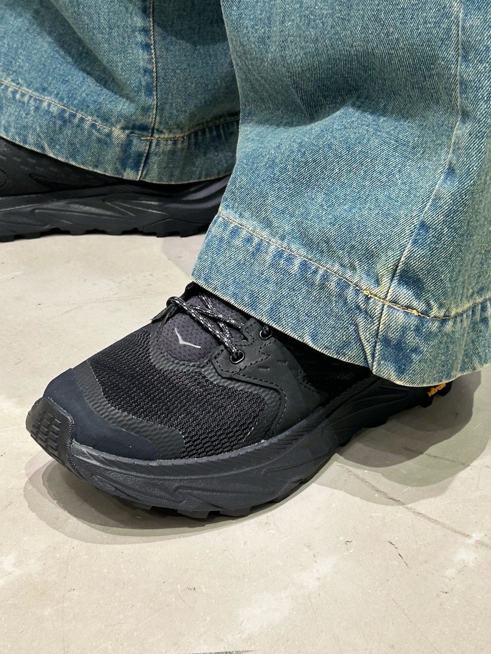 ブラック系のカーディガン/ボレロ、ブラック系のスニーカーを着用したメンズの春コーディネートの6枚目の写真