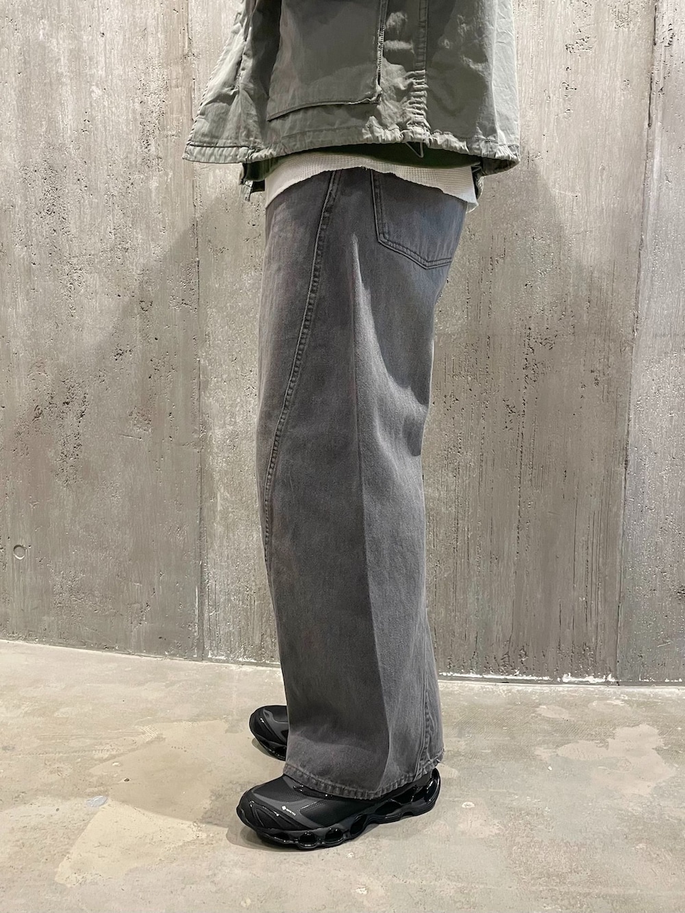グリーン系のミリタリージャケット、グレー系のデニムパンツ、ホワイト系のTシャツ/カットソーを着用したメンズの冬コーディネートの4枚目の写真