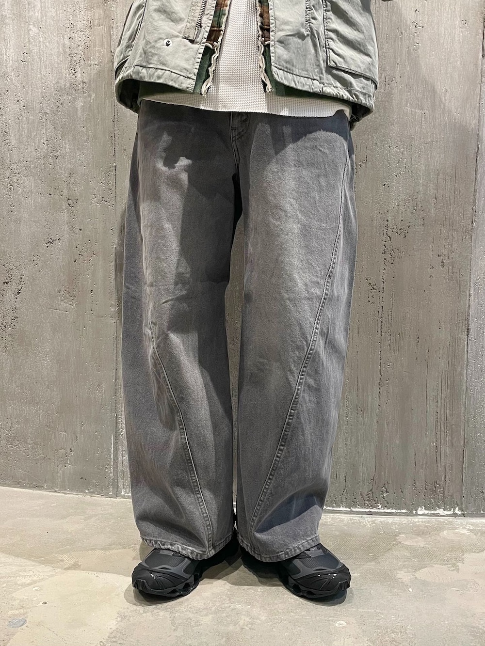 グリーン系のミリタリージャケット、グレー系のデニムパンツ、ホワイト系のTシャツ/カットソーを着用したメンズの冬コーディネートの3枚目の写真