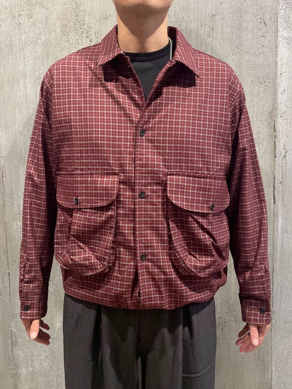 グレー系のスラックス、レッド系のシャツ/ブラウス、ブラック系のTシャツ/カットソーを着用したメンズの秋コーディネートの2枚目の写真