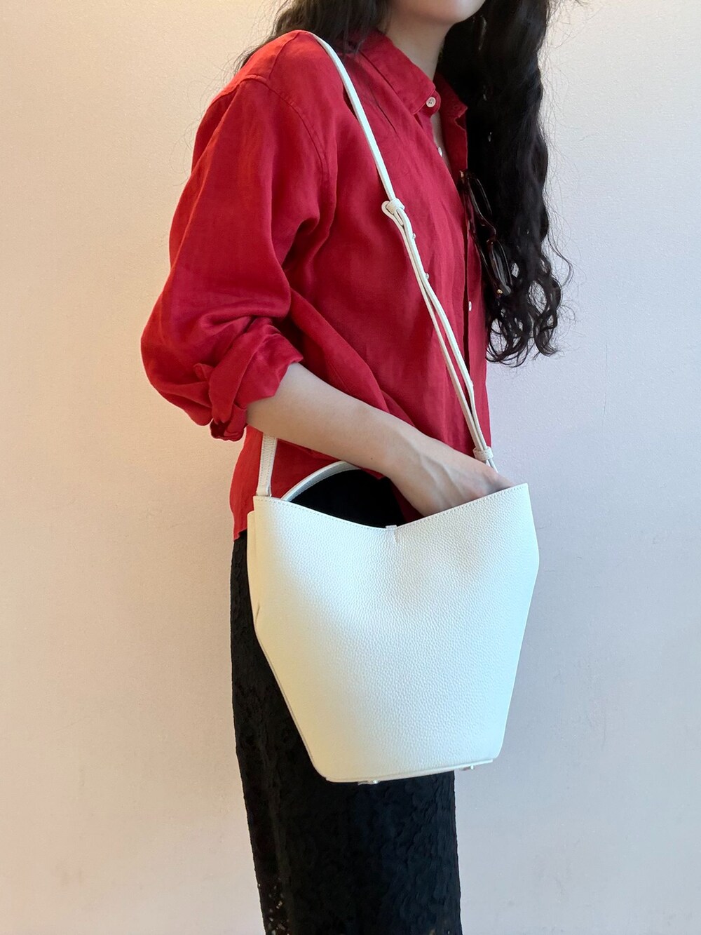 ブラック系のその他パンツ、レッド系のシャツ/ブラウス、ホワイト系のハンドバッグを着用したレディースの春コーディネートの2枚目の写真