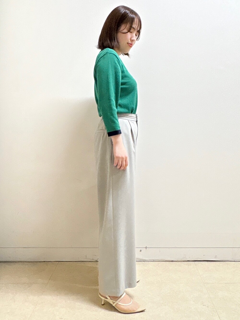 グレー系のその他パンツ、ブルー系のショルダーバッグ、グリーン系のニット/セーターを着用したレディースの春コーディネートの5枚目の写真