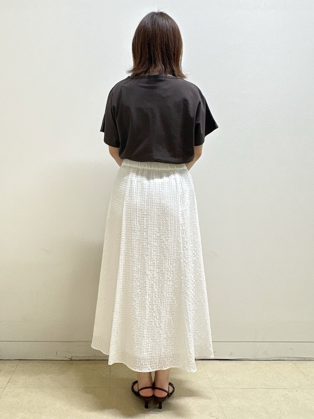 ブラウン系のTシャツ/カットソー、イエロー系のカーディガン/ボレロ、ホワイト系のスカートを着用したレディースの夏コーディネートの9枚目の写真