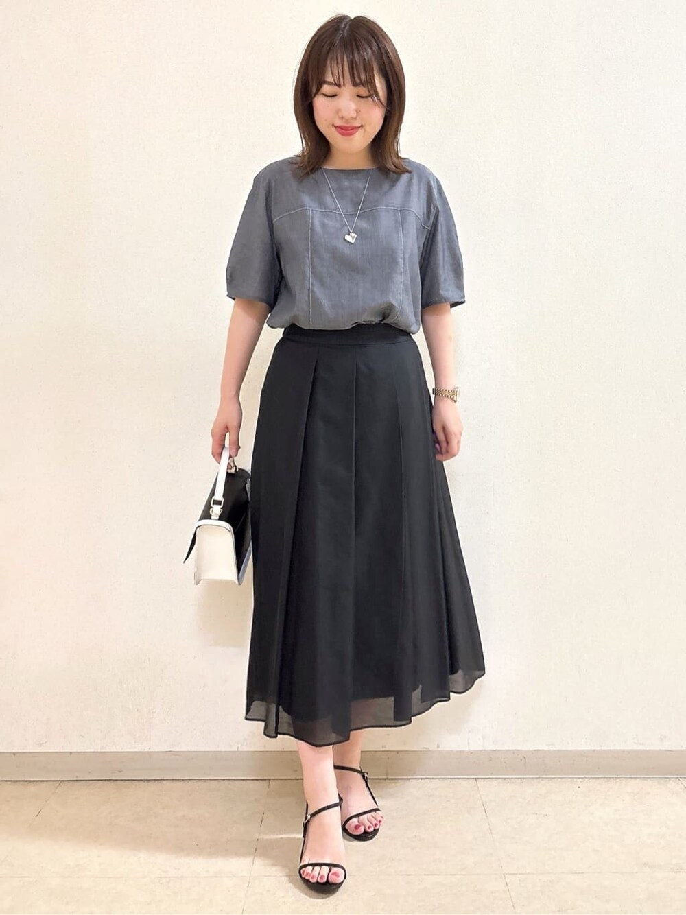 ブルー系のシャツ/ブラウス、ブラック系のスカート、ブラック系のショルダーバッグを着用したレディースの夏コーディネートの4枚目の写真