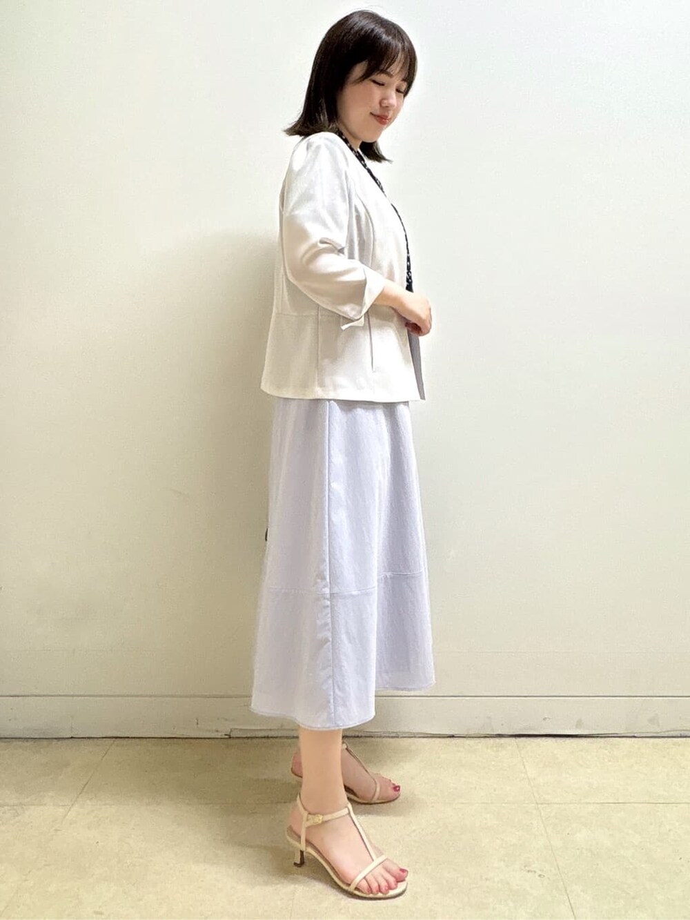 ベージュ系のノーカラージャケット、ブルー系のシャツ/ブラウス、パープル系のスカートを着用したレディースの夏コーディネートの5枚目の写真