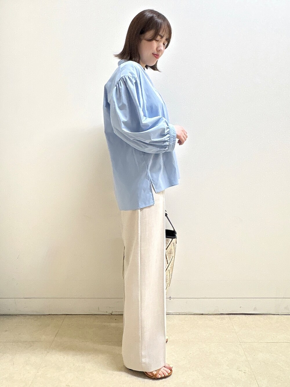 ベージュ系のショルダーバッグ、ブルー系のシャツ/ブラウス、ベージュ系のその他パンツを着用したレディースの春コーディネートの6枚目の写真