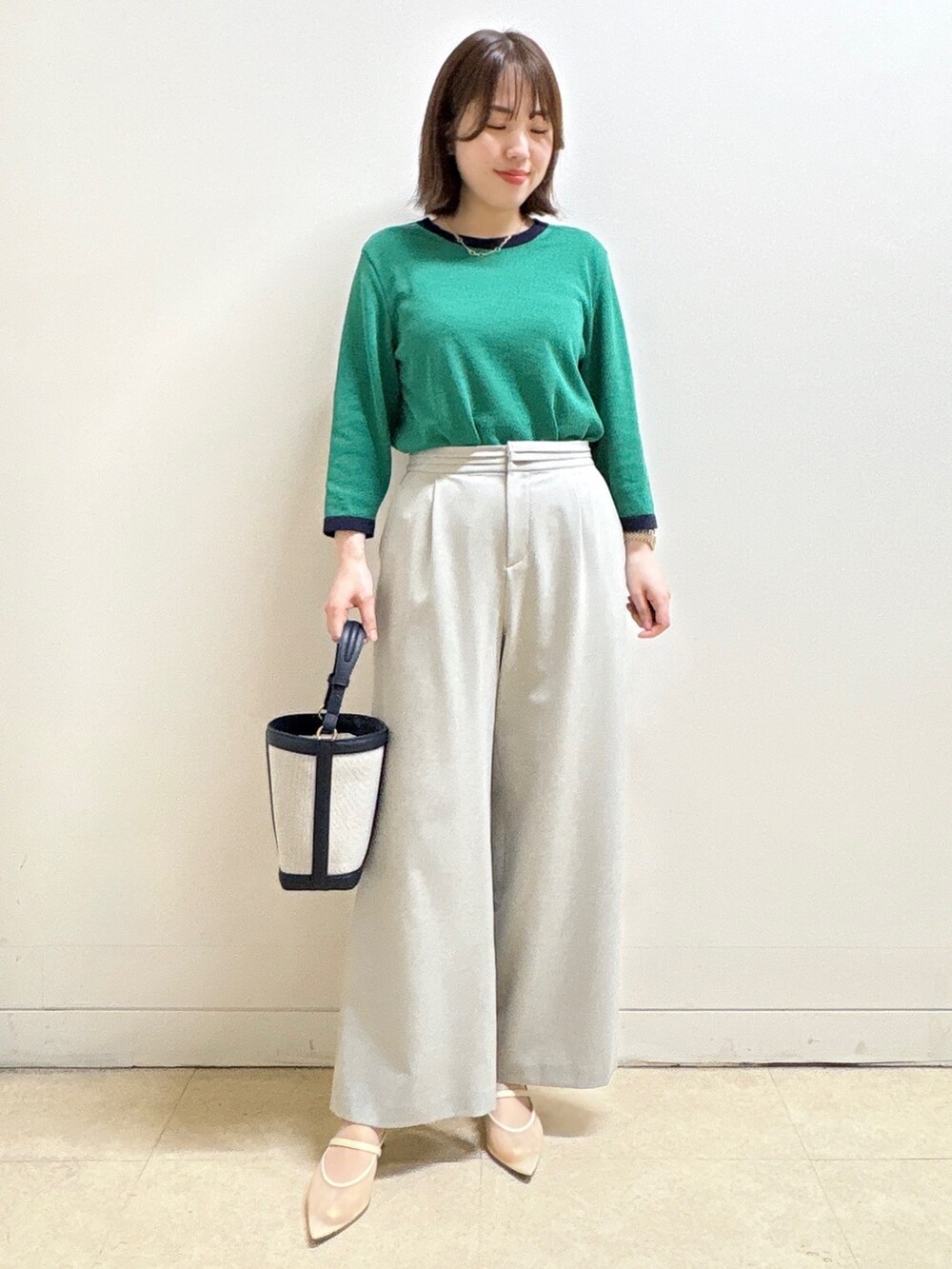 グレー系のその他パンツ、ブルー系のショルダーバッグ、グリーン系のニット/セーターを着用したレディースの春コーディネートの3枚目の写真