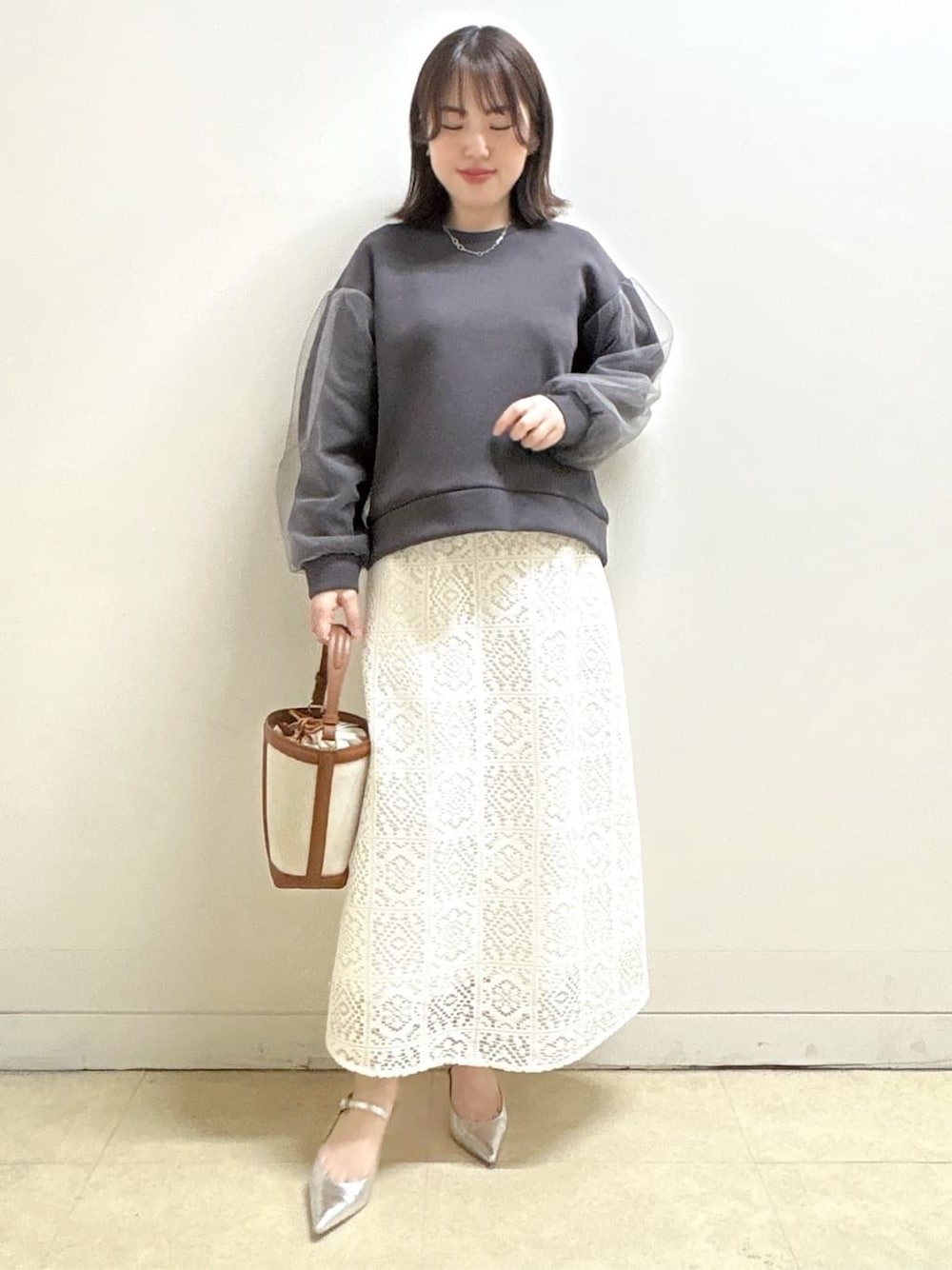 ホワイト系のスカート、グレー系のTシャツ/カットソー、イエロー系のショルダーバッグを着用したレディースの冬コーディネートの3枚目の写真