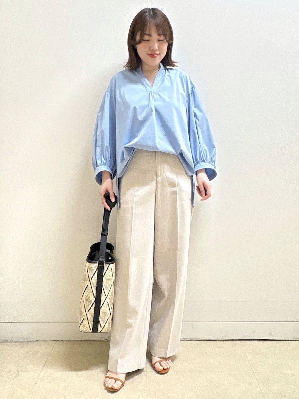 ベージュ系のショルダーバッグ、ブルー系のシャツ/ブラウス、ベージュ系のその他パンツを着用したレディースの春コーディネートの2枚目の写真