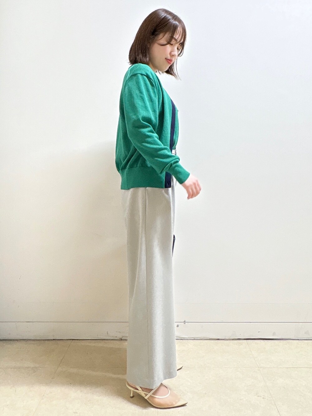 グレー系のその他パンツ、ブルー系のショルダーバッグ、グリーン系のニット/セーターを着用したレディースの春コーディネートの9枚目の写真