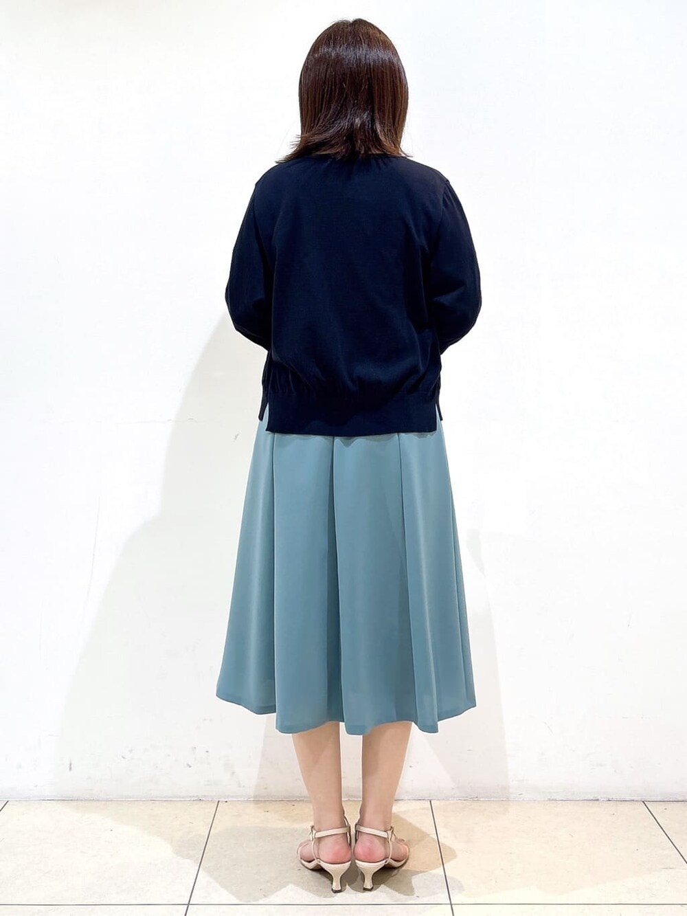 ブルー系のカーディガン/ボレロ、ホワイト系のTシャツ/カットソー、グリーン系のスカートを着用したレディースの夏コーディネートの6枚目の写真