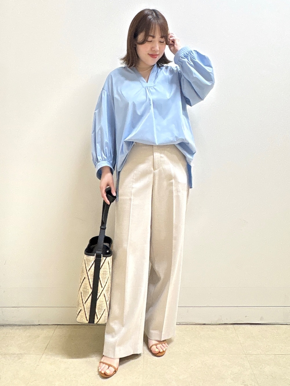 ベージュ系のショルダーバッグ、ブルー系のシャツ/ブラウス、ベージュ系のその他パンツを着用したレディースの春コーディネートの3枚目の写真