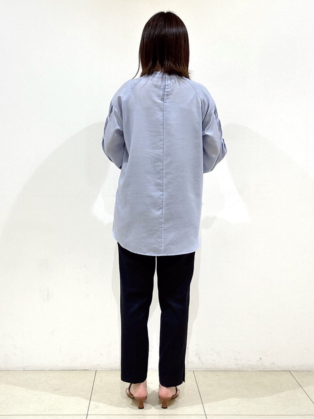 ブルー系のシャツ/ブラウス、ブルー系のその他パンツ、ホワイト系のハンドバッグを着用したレディースの春コーディネートの6枚目の写真