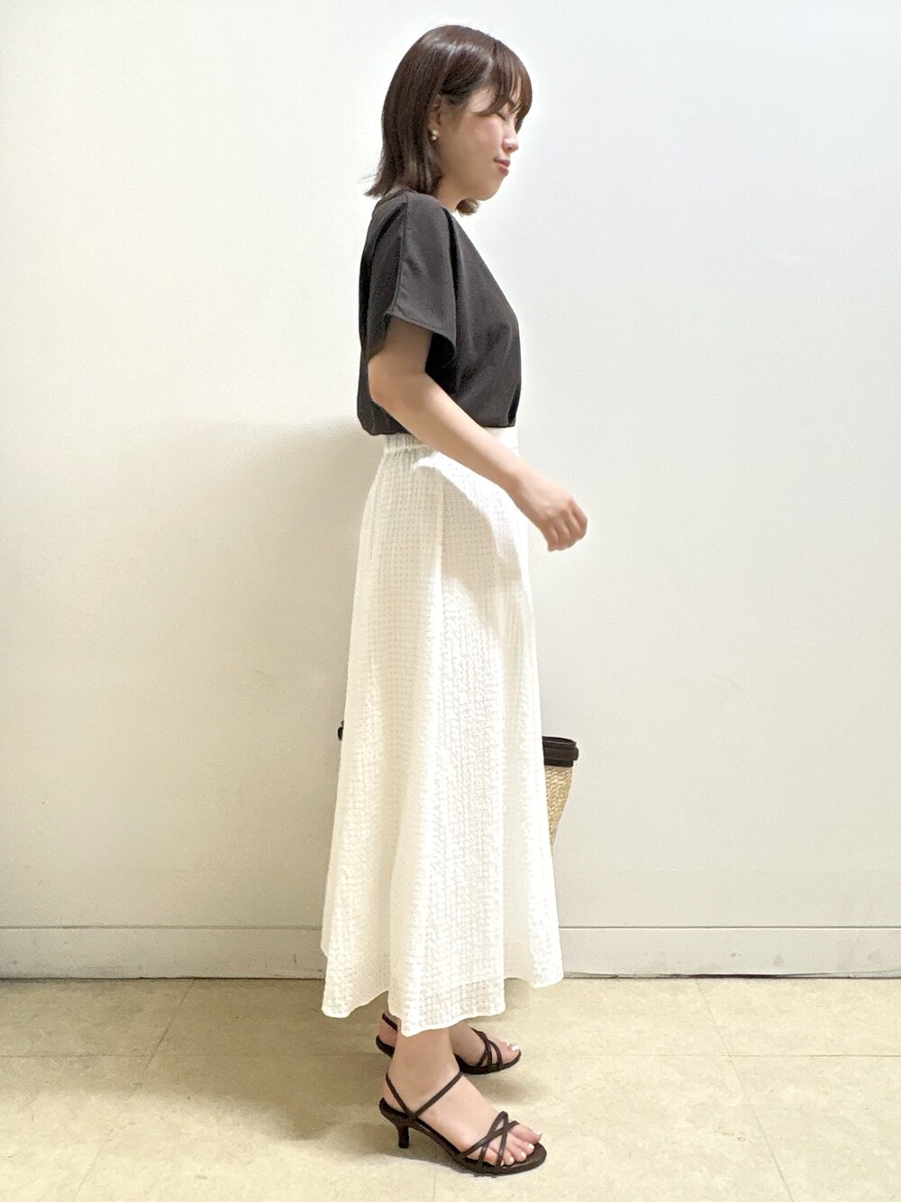 ブラウン系のTシャツ/カットソー、イエロー系のカーディガン/ボレロ、ホワイト系のスカートを着用したレディースの夏コーディネートの8枚目の写真