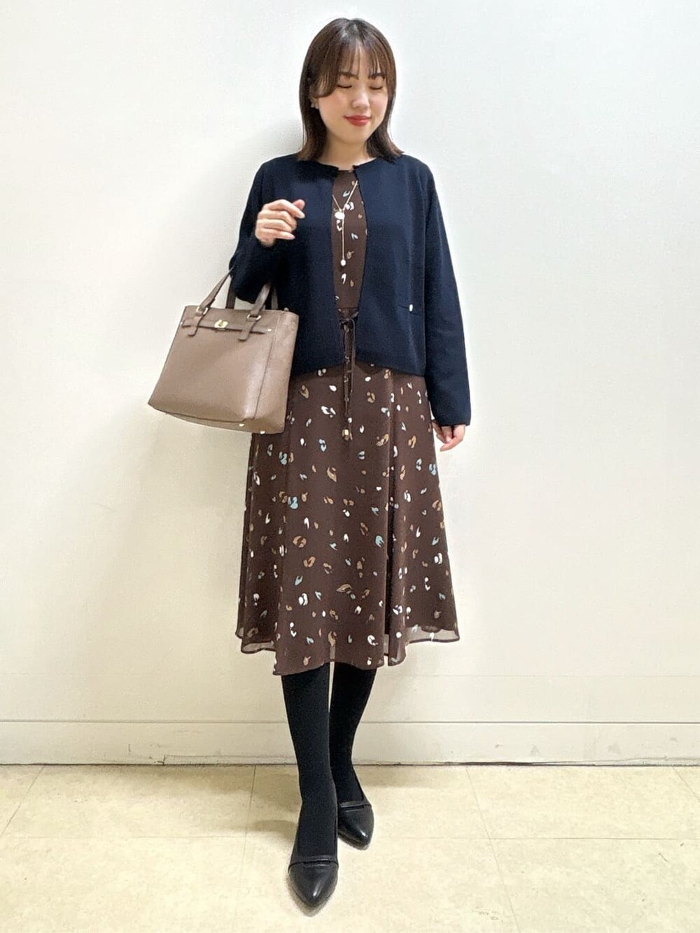 ブルー系のカーディガン/ボレロ、ブラウン系のワンピース、ブラック系のパンプスを着用したレディースの冬コーディネートの3枚目の写真