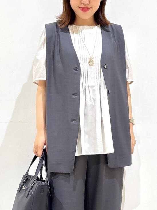 ベージュ系のシャツ/ブラウス、ベージュ系のパンプス、ブラック系のハンドバッグを着用したレディースの秋コーディネートの10枚目の写真