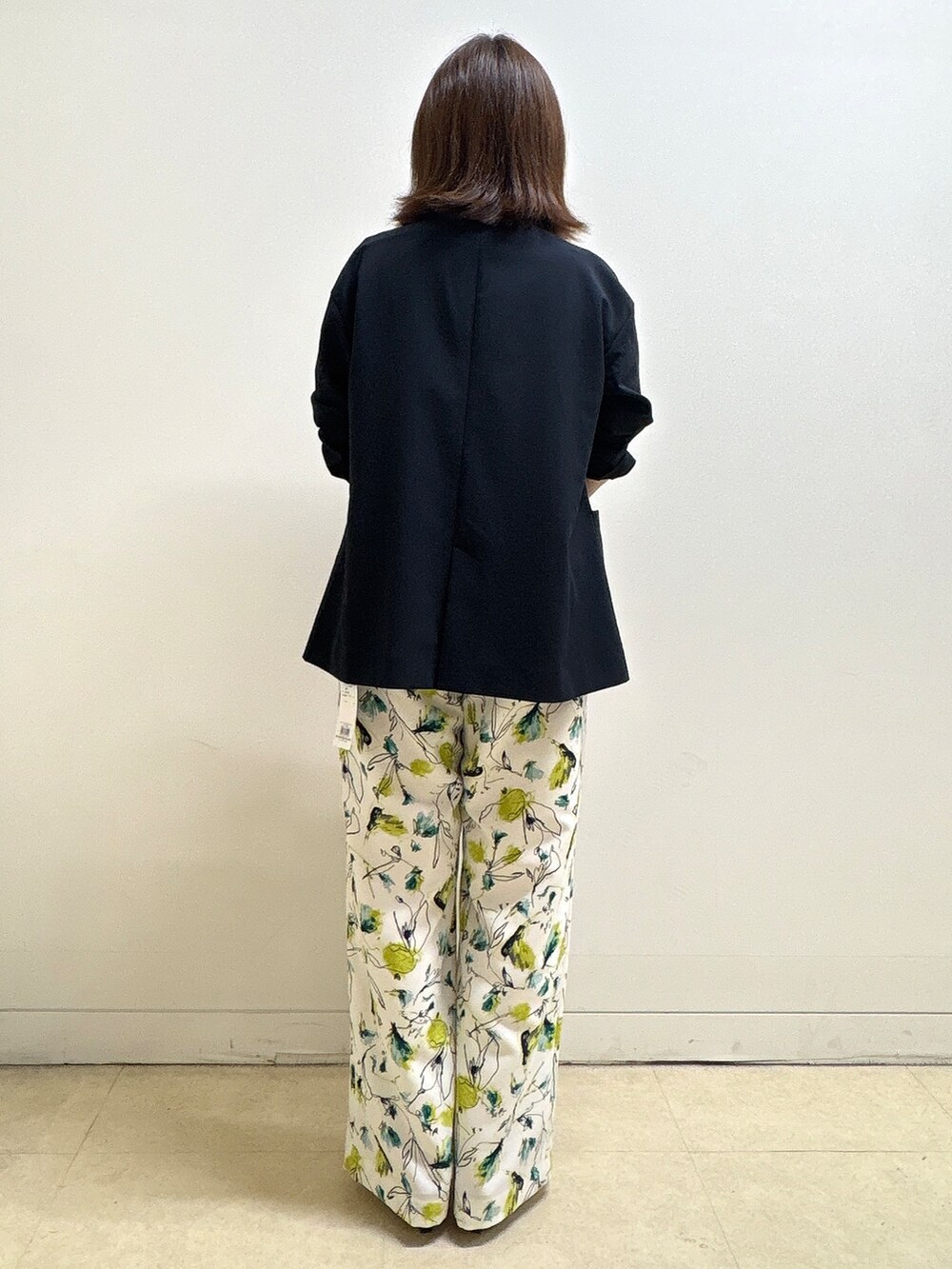 ホワイト系のニット/セーター、ベージュ系のその他パンツ、オレンジ系のショルダーバッグを着用したレディースの夏コーディネートの9枚目の写真