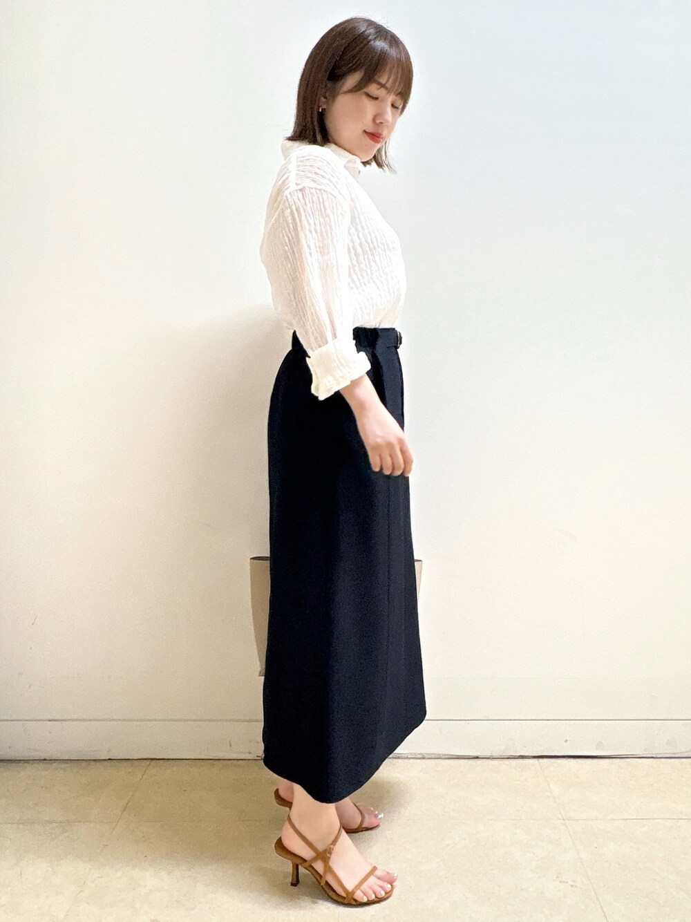 ホワイト系のシャツ/ブラウス、ブルー系のスカート、ベージュ系のトートバッグを着用したレディースの夏コーディネートの5枚目の写真