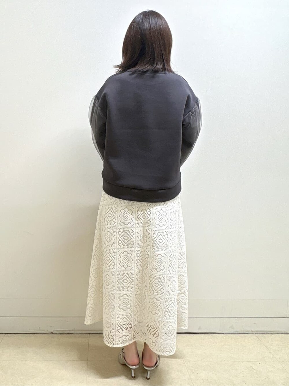 ホワイト系のスカート、グレー系のTシャツ/カットソー、イエロー系のショルダーバッグを着用したレディースの冬コーディネートの6枚目の写真