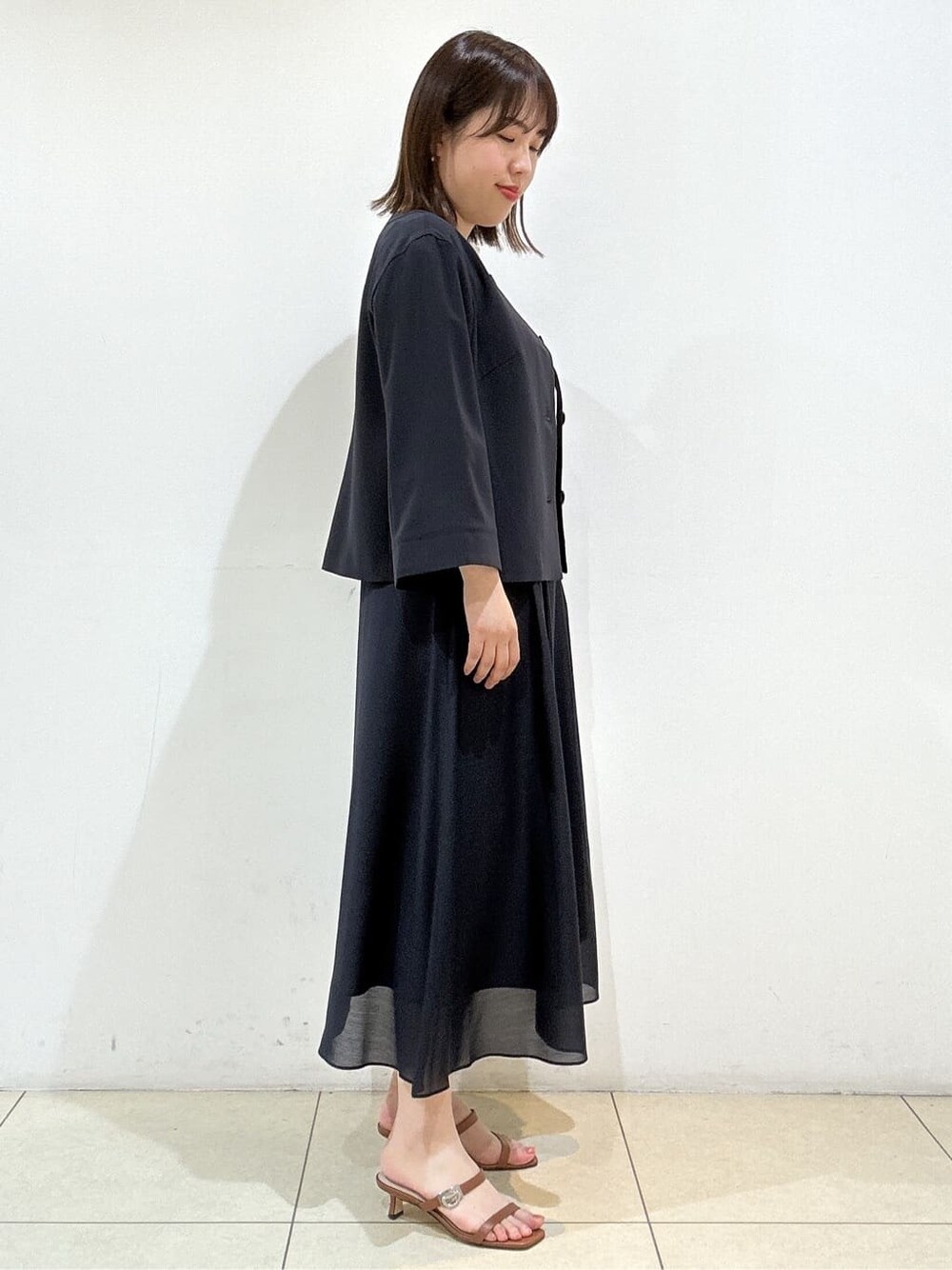 ブルー系のノーカラージャケット、ベージュ系のシャツ/ブラウス、ブルー系のスカートを着用したレディースの春コーディネートの5枚目の写真