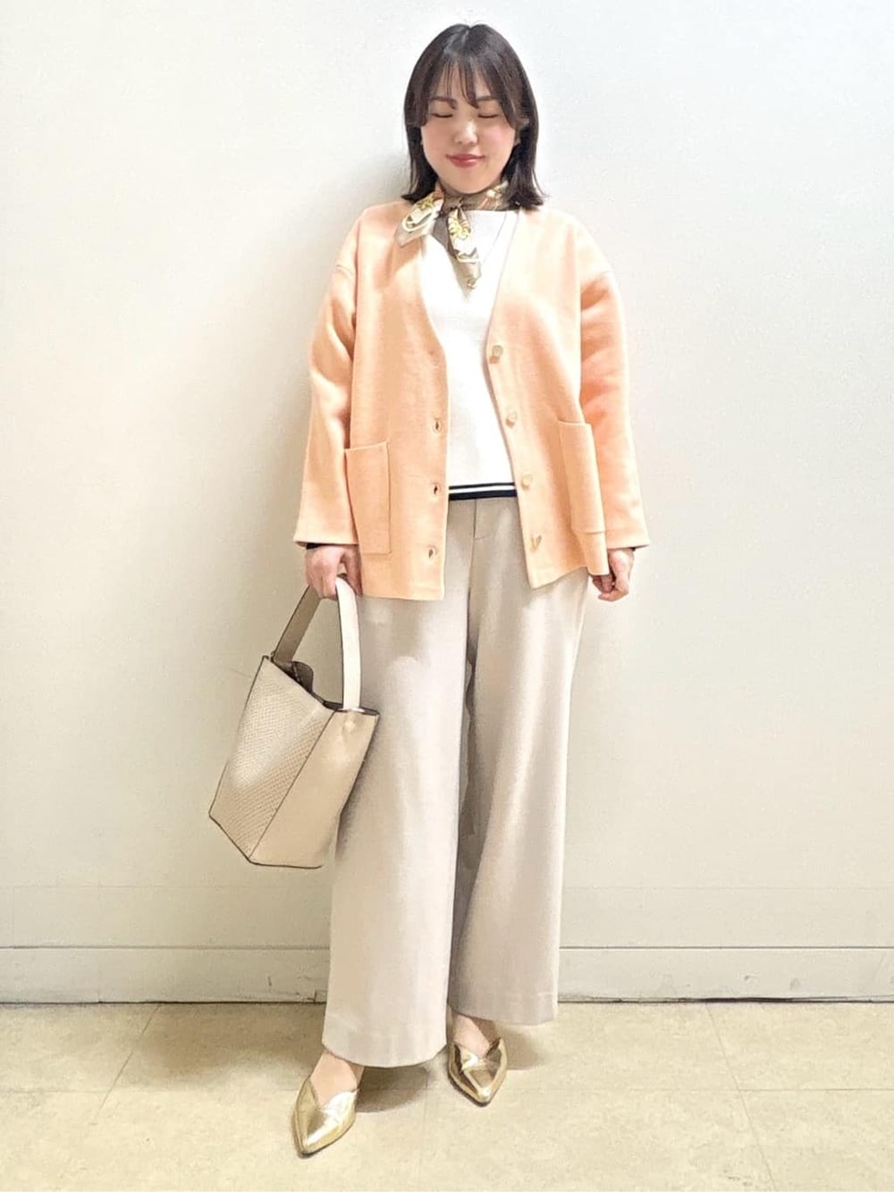 ベージュ系のその他パンツ、ホワイト系のニット/セーター、オレンジ系のカーディガン/ボレロを着用したレディースの冬コーディネートの7枚目の写真