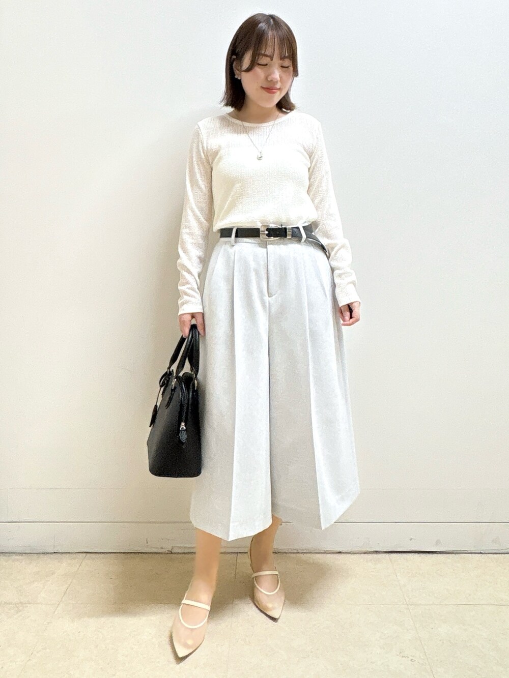 ブラック系のハンドバッグ、ホワイト系のTシャツ/カットソー、グレー系のブルゾンを着用したレディースの春コーディネートの7枚目の写真