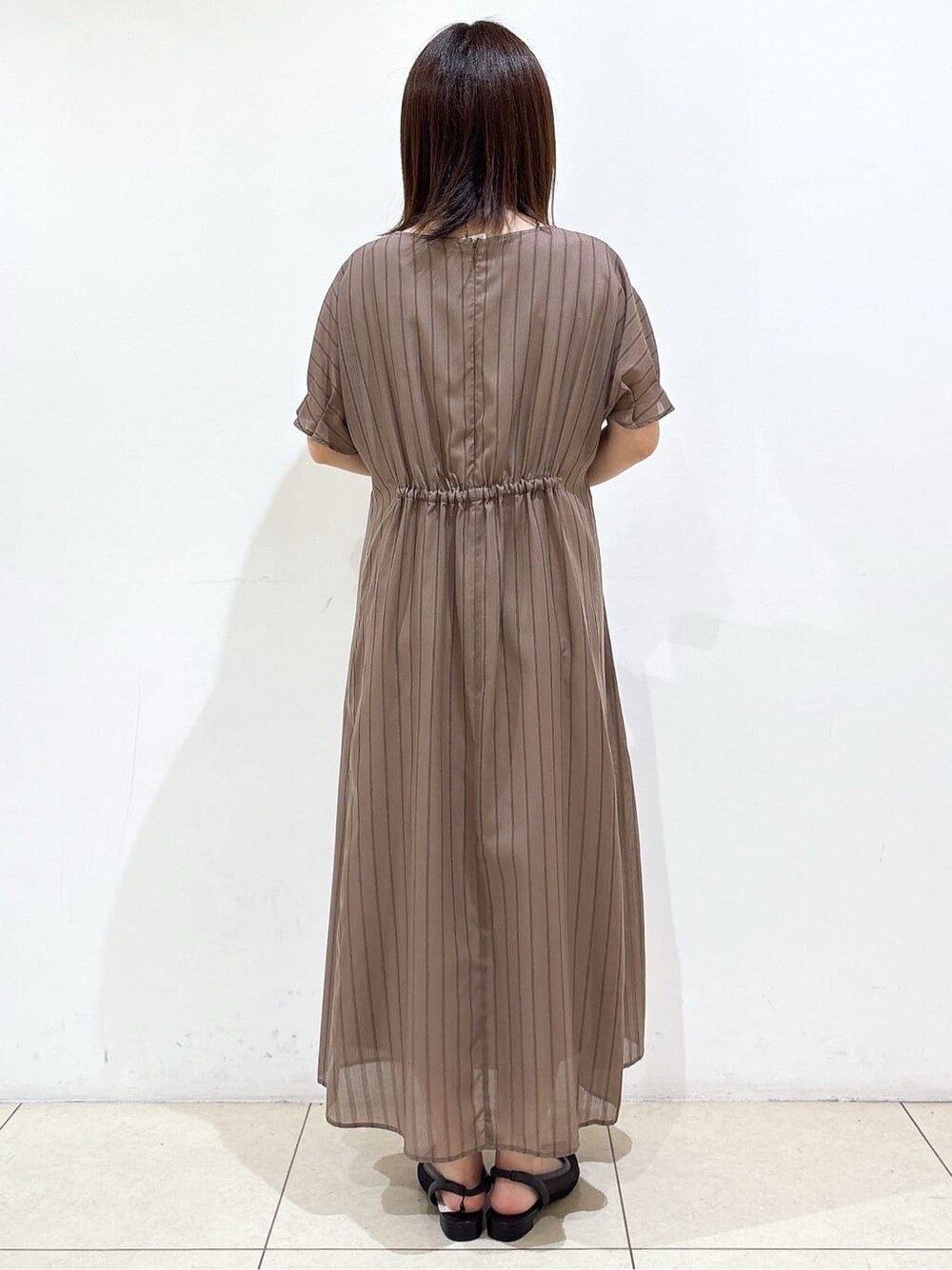 ブラウン系のワンピース、ブラック系のパンプス、ブラック系のハンドバッグを着用したレディースの夏コーディネートの7枚目の写真