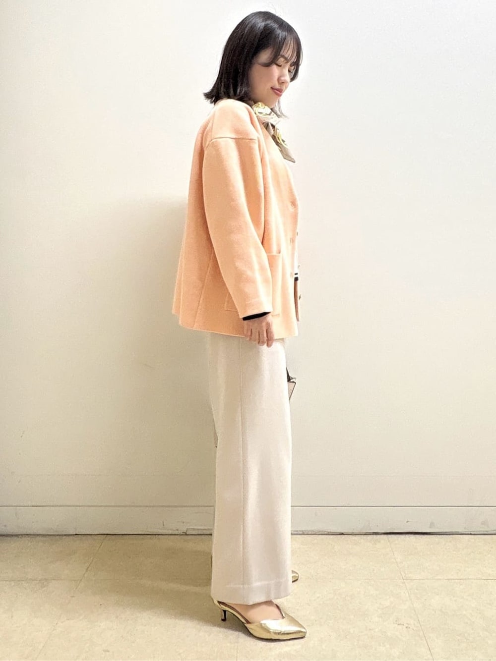 ベージュ系のその他パンツ、ホワイト系のニット/セーター、オレンジ系のカーディガン/ボレロを着用したレディースの冬コーディネートの8枚目の写真