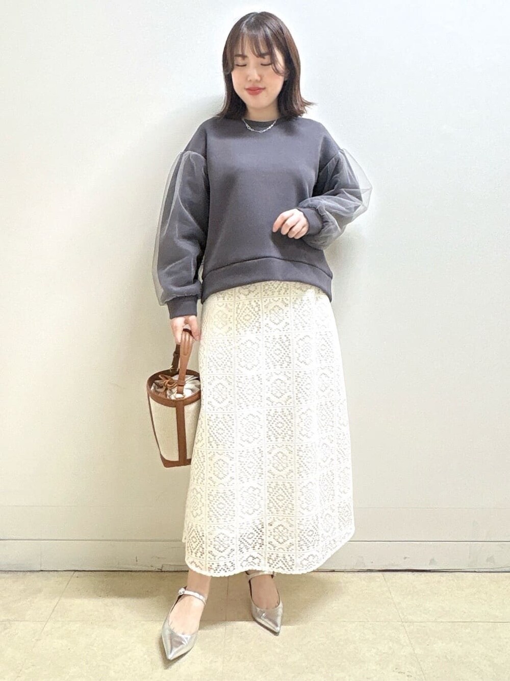 ホワイト系のスカート、グレー系のTシャツ/カットソー、イエロー系のショルダーバッグを着用したレディースの冬コーディネートの4枚目の写真