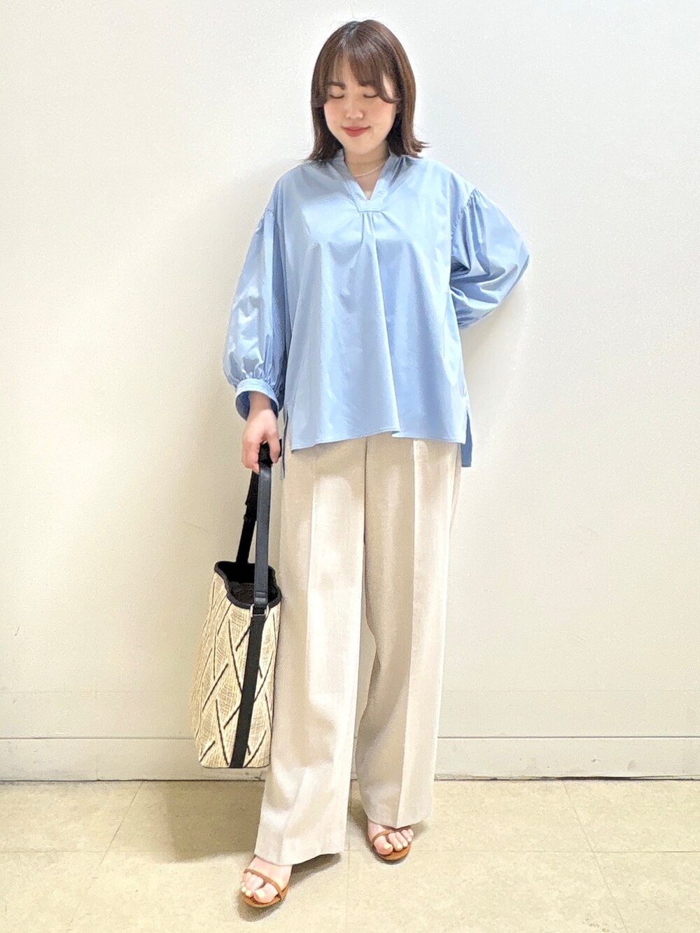 ベージュ系のショルダーバッグ、ブルー系のシャツ/ブラウス、ベージュ系のその他パンツを着用したレディースの春コーディネートの5枚目の写真
