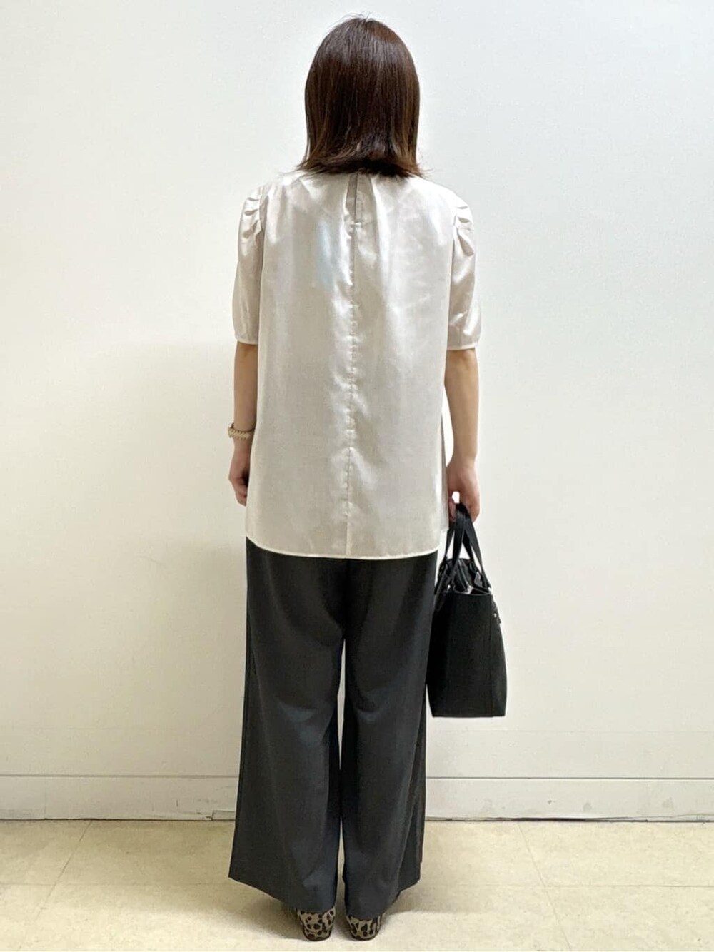ベージュ系のシャツ/ブラウス、ベージュ系のパンプス、ブラック系のハンドバッグを着用したレディースの秋コーディネートの6枚目の写真